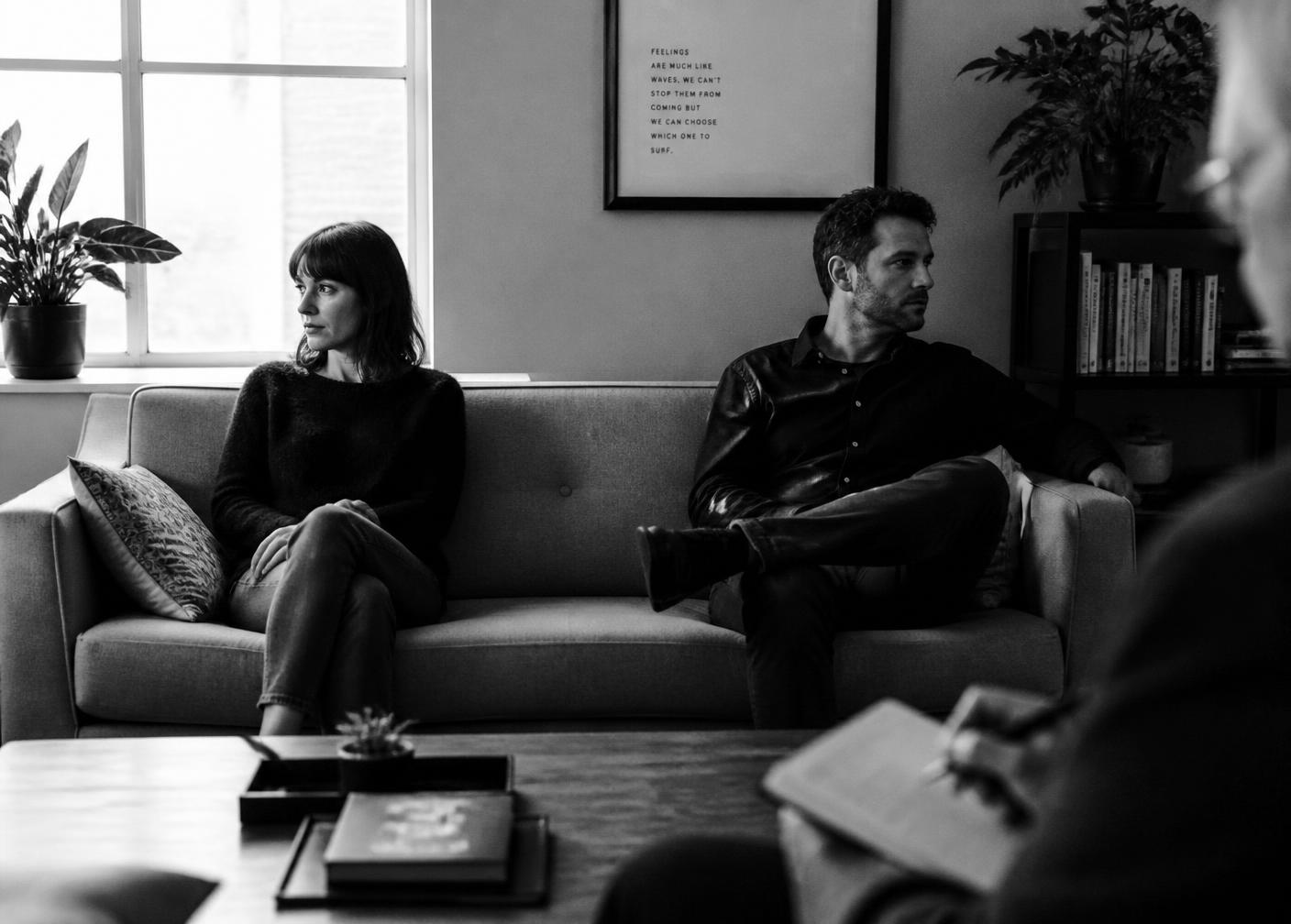A couple seated on a sofa during a therapy session